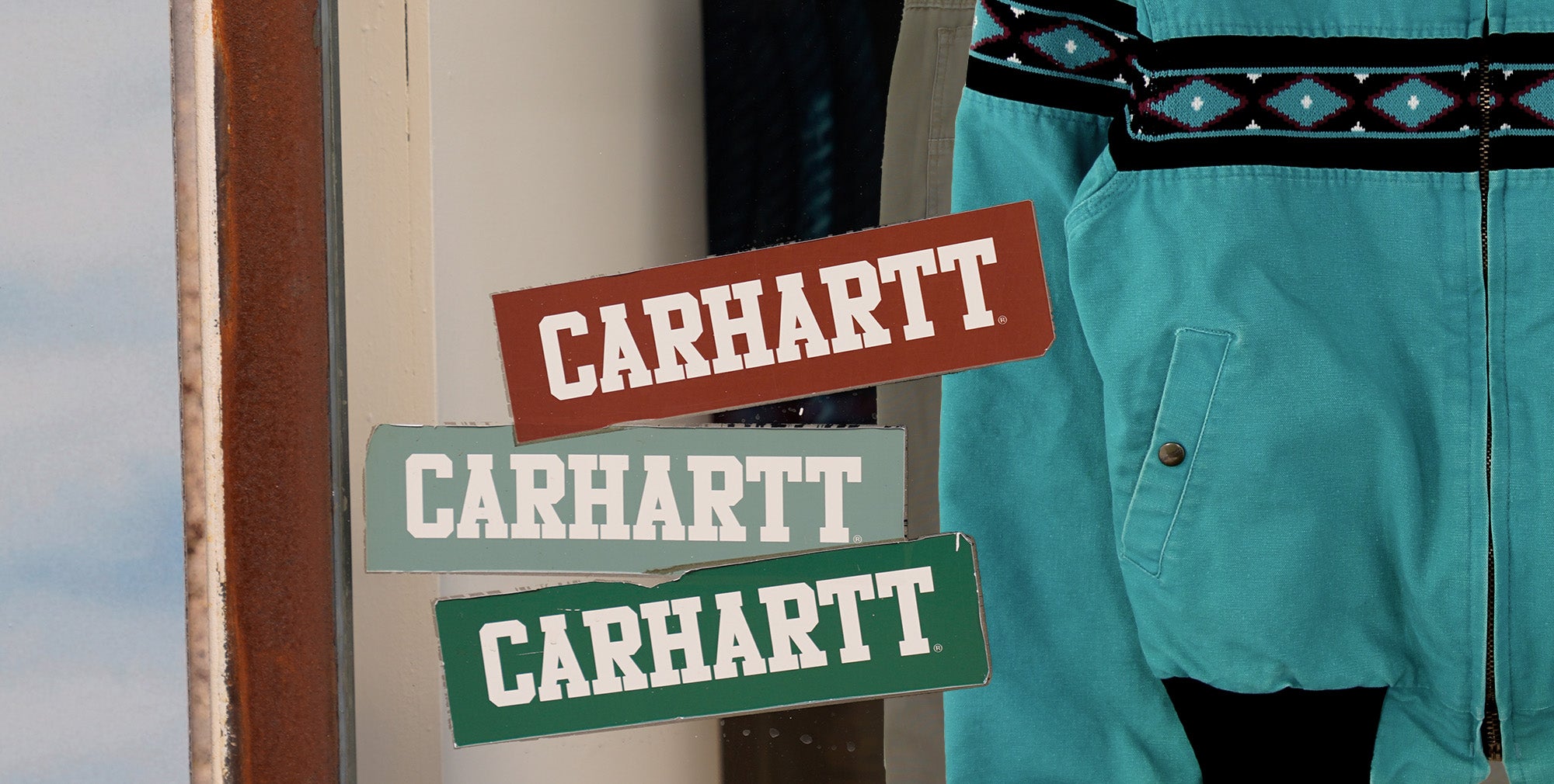 Shop window with Carhartt Santa Fe jacket on display.
